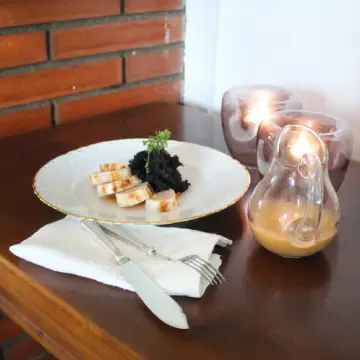 Calamares rellenos de pescado y gambas, esponja de tinta y salsa Oñana en la mesa auxiliar