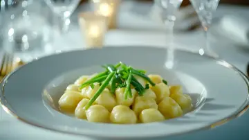 Ñoquis de conejo, crema de espárragos blancos y judias verdes, en mesa montada