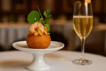 Croquetas cremosas de gambas al ajillo y chips de ajo dorado sobre pie de tarta